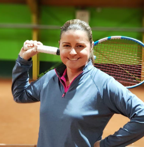 Tennislehrerin Filipa lächelnd in der Tennishalle.